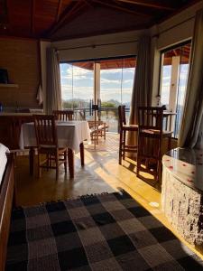 a living room with a table and chairs with a view at Chalés Terras Altas in Gonçalves