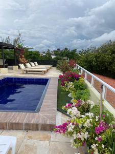 a garden with flowers and a swimming pool at Pousada Delicias da vila in Jericoacoara