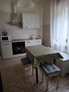 Una cocina con una mesa y dos sillas y un fregadero. en B&B Balcone sul Fiume, en Zogno