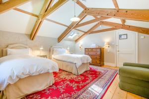 two beds in a room with a red rug at 6 Bed in Tresillian oc-t32987 in Newlyn East