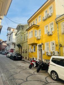 a yellow building with motorcycles parked on a street at Grand Süleymaniye Hotel in Istanbul