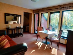 a living room with a table and chairs and windows at Grafo Zubovo Hotel & SPA in Bubiai