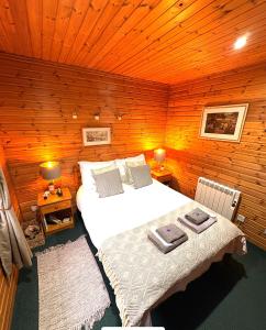 a bedroom with a large bed in a wooden room at Braemar Lodge Cabins Not for profit in Braemar