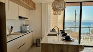 a kitchen with a counter with a view of the ocean at Hermoso Departamento in Manta