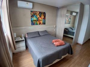 a small bedroom with a bed and a mirror at Flats da Júnia no Paris Residence in Lagoa Santa