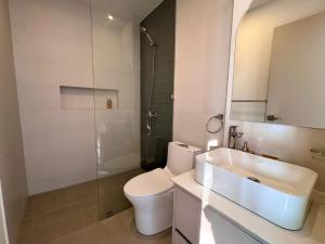 a bathroom with a toilet and a sink and a shower at Hermoso Departamento in Manta +33 photos