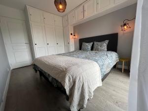 1 dormitorio con 1 cama grande y armarios blancos en appartement bord de mer, en Benerville-sur-Mer 17 fotos más