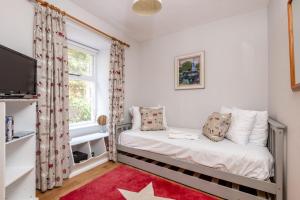 une petite chambre avec un lit et une fenêtre dans l'établissement The Old Bank House - St Monans, à Saint Monance