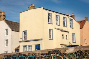 un grand bâtiment en briques avec des fenêtres sur son côté dans l'établissement The Old Bank House - St Monans, à Saint Monance