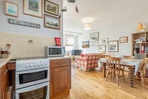 une cuisine et une salle à manger avec une cuisinière et un micro-ondes dans l'établissement The Old Bank House - St Monans, à Saint Monance