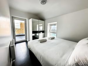 a bedroom with a large white bed and a mirror at KCM Urban Retreats in Cobh