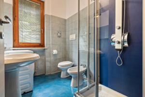 a bathroom with a toilet and a glass shower at Casa Tuly in Brenzone sul Garda +24 photos
