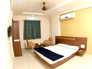 a bedroom with a bed and a table and chairs at Hotel Rahi Inn in Vadodara
