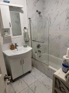 a white bathroom with a sink and a shower at designer abode condo min to Manhattan in jersey city in Jersey City +2 photos