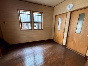 een lege kamer met een klok aan de muur bij 桑名のお宿三栄町 in Kuwana