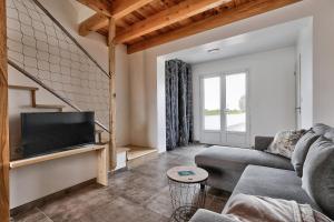 ein Wohnzimmer mit Sofa und Fernseher in der Unterkunft La Guérinière - 650m de la plage - Jardin in La Guérinière