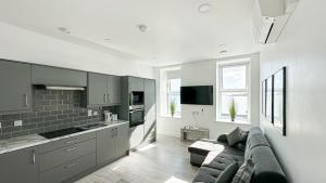 a living room with a couch and a kitchen at KCM Urban Retreats in Cobh