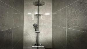 a shower with a shower head in a bathroom at KCM Urban Retreats in Cobh +160 photos