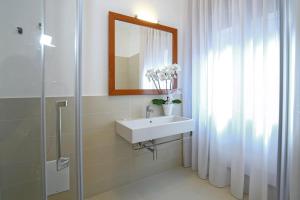 uma casa de banho com um lavatório, um espelho e um chuveiro em Starhost - GOLDEN SUITE em Salerno