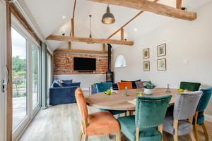 a dining room with a wooden table and chairs at Iken Barn in Neatishead