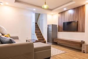 a living room with a couch and a tv at Dfour Home Hang Bo - Hanoi Old Quarter in Hanoi