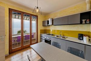 a kitchen with a sink and a table with a view at Casa Tuly 1 in Brenzone sul Garda