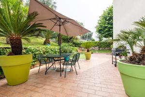a patio with a table and chairs and an umbrella at Casa Tuly 1 in Brenzone sul Garda