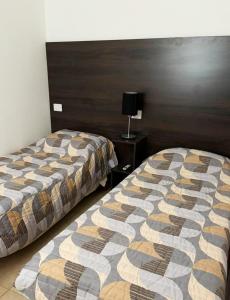 une chambre d'hôtel avec 2 lits et une table de nuit dans l'établissement Norita Alquiler Temporal - Departamento, à La Rioja