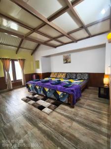 a bedroom with a bed with a purple comforter at Pleasant Stay Coonoor-A Serene Hillside Retreat in Coonoor