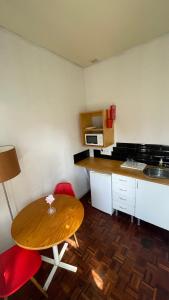 a small kitchen with a wooden table and red chairs at Pink Yellow Porto Apart in Porto