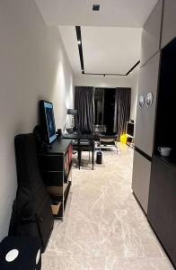 a living room with a couch and a table with a television at NICOLE's travel room in Fontana