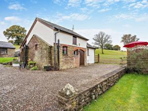 Llanvetherineにある1 Bed in Abergavenny BN092の石垣の横に赤傘を持つ家