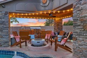 a patio with chairs and a grill with lights at Luxury 6BR Retreat - Pool BBQ Theater and Games in Lemontree
