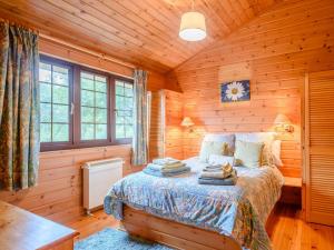 a bedroom with a bed in a log cabin at 3 Bed in Clovelly 00374 in Clovelly