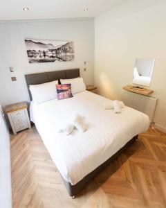 een slaapkamer met een groot bed met twee handdoeken erop bij Great Gable Riverside Luxury Lodge in Keswick