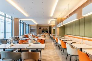 an empty dining room with tables and chairs at Holiday Inn Express Shanghai Changyang Road by IHG in Shanghai