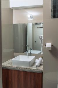 een badkamer met een witte wastafel en een spiegel bij Nuna Atelier in Cuzco +29 foto's