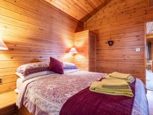 a bedroom with a bed in a wooden cabin at 2 Bed in Clovelly 00361 in Clovelly