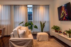 een woonkamer met een witte bank en een raam bij Nuna Atelier in Cuzco