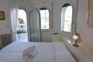 a bedroom with a white bed with three windows at RNET - Port Primer Empuriabrava in Empuriabrava
