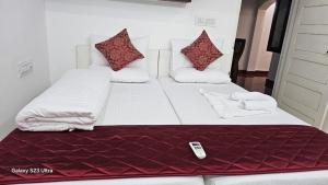uma cama com um controle remoto sentado em cima dela em The Signature Suites em Edappally