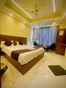 a hotel room with a large bed and a desk at Hotel Mount View Inn with terrace Ganga view in Rishīkesh