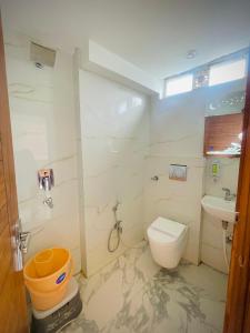 a bathroom with a toilet and a sink at Hotel Mount View Inn with terrace Ganga view in Rishīkesh +7 photos