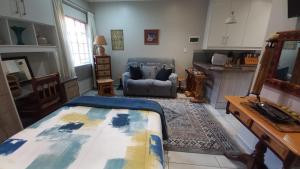 a bedroom with a bed and a chair in a room at Granny at Umgeni in Pretoria