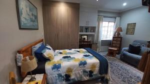 a bedroom with a bed and a living room at Granny at Umgeni in Pretoria