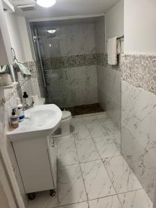 a bathroom with a sink and a toilet and a shower at designer abode condo min to Manhattan in jersey city in Jersey City