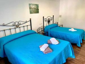 two blue beds in a room with towels on them at Casa Campoamor By Solymar Holiday in Cogollos de Guadix +38 photos