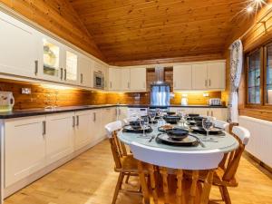 a kitchen with a table and chairs and wooden ceilings at 4 Bed in Clovelly 00360 in Clovelly +14 photos
