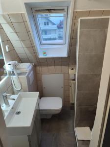 ein Badezimmer mit Toilette und Waschbecken und einem Fenster in der Unterkunft Zimmer in Stadtnähe in Detmold