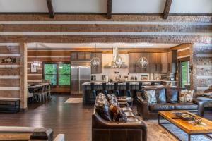 Una gran sala de estar con muebles de cuero y una cocina. en Above and Beyond, en Boone